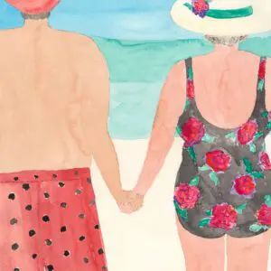 Two women in swimsuits holding hands by the ocean.